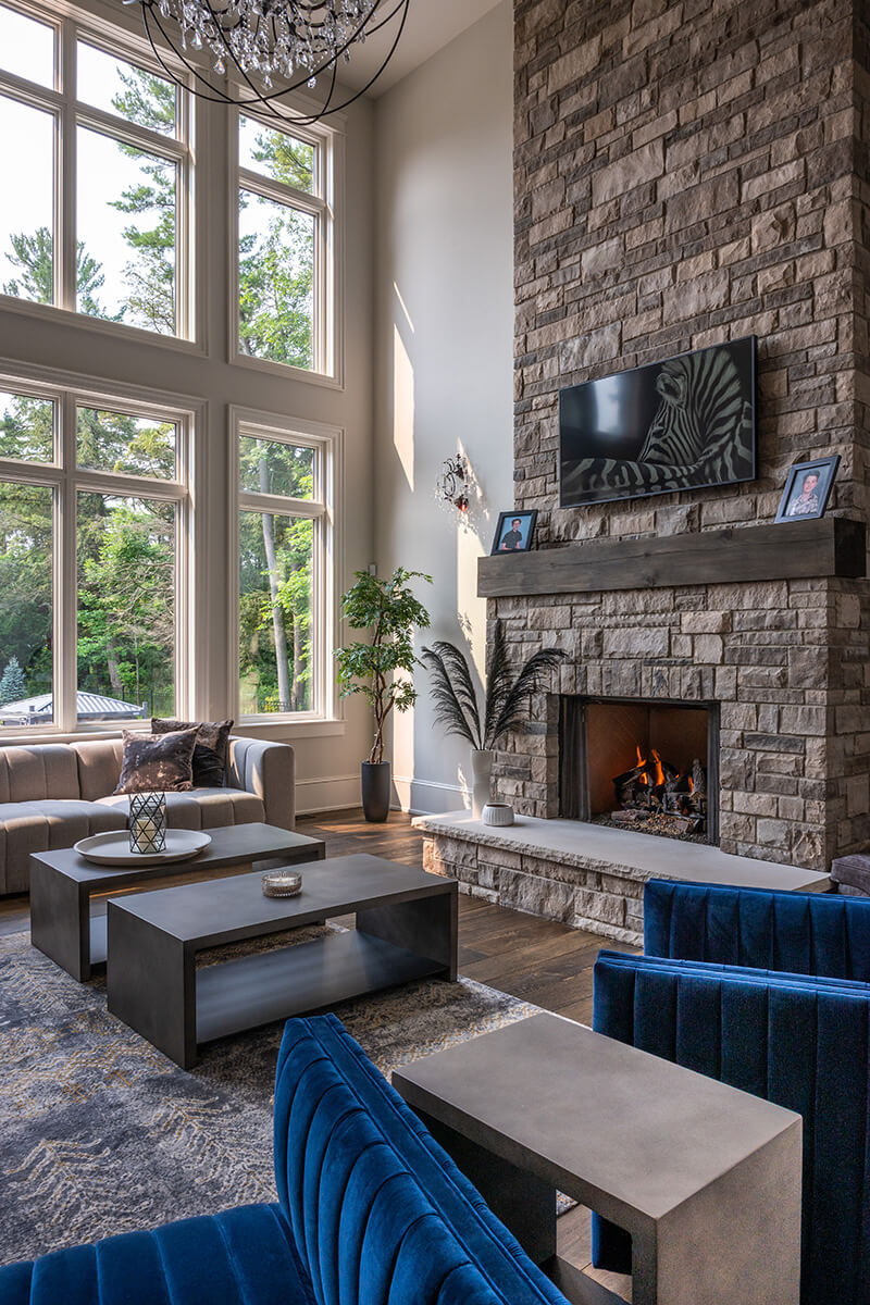 Custom Living Room Design With Stone Fireplace & Blue Chairs
